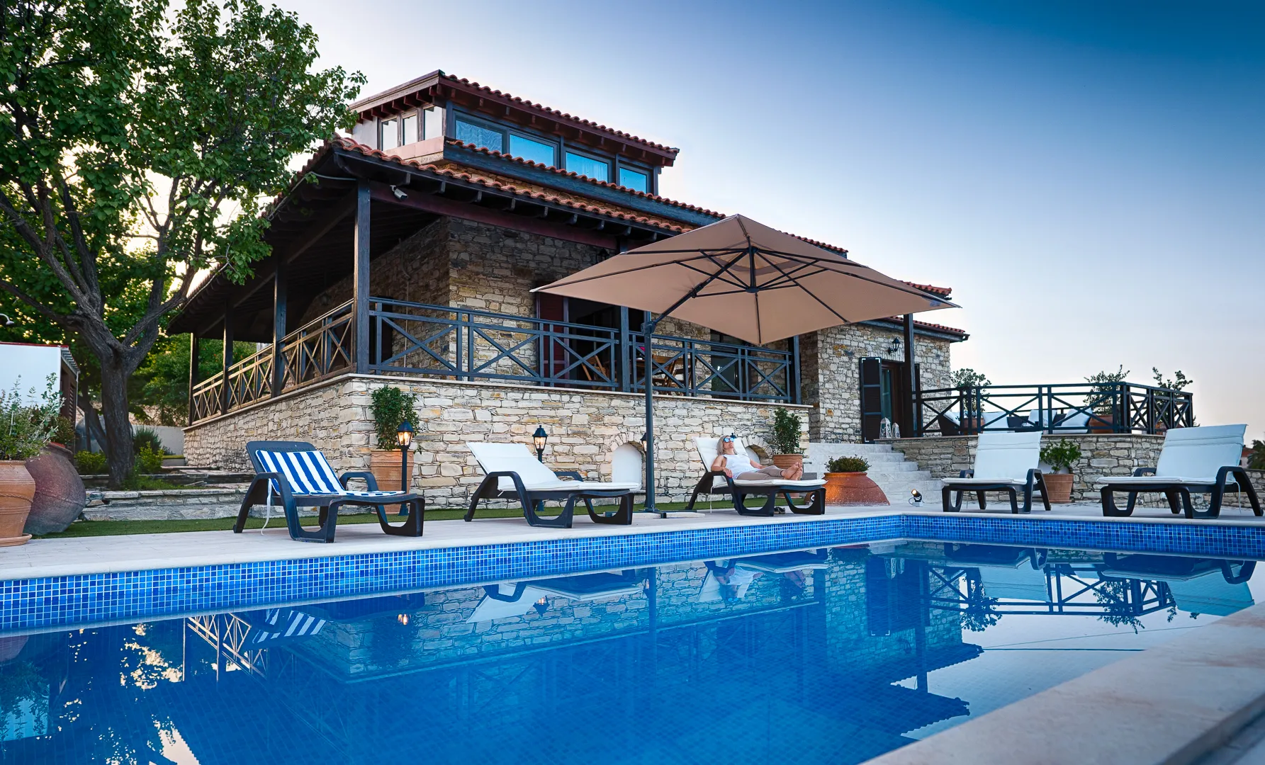 Pool, sunbeds and umbrella by the villa