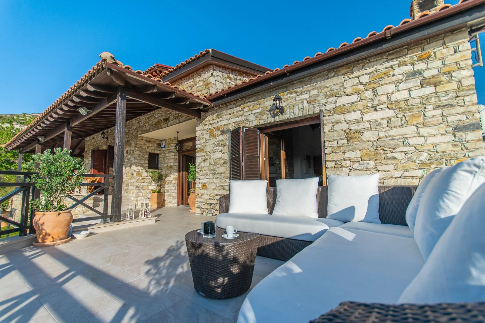 Outdoor sofa and coffee table on Lefkara Villa’s sunny stone terrace
