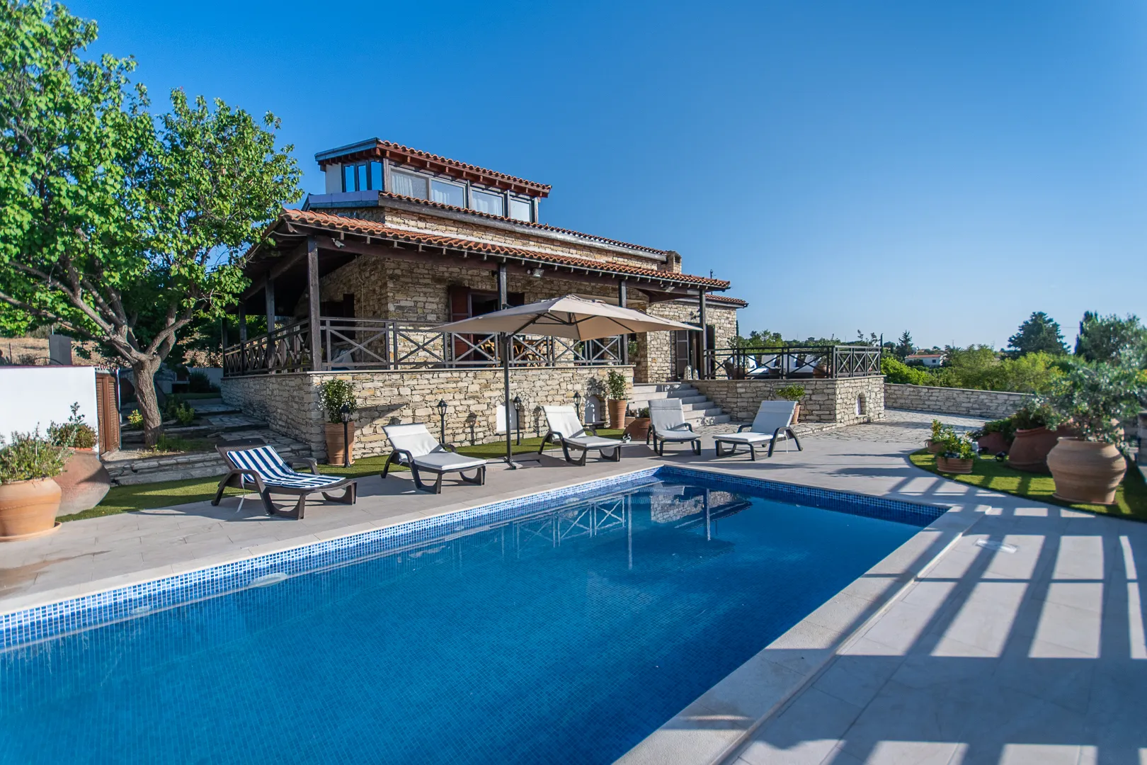 Pool and stone villa on a sunny day